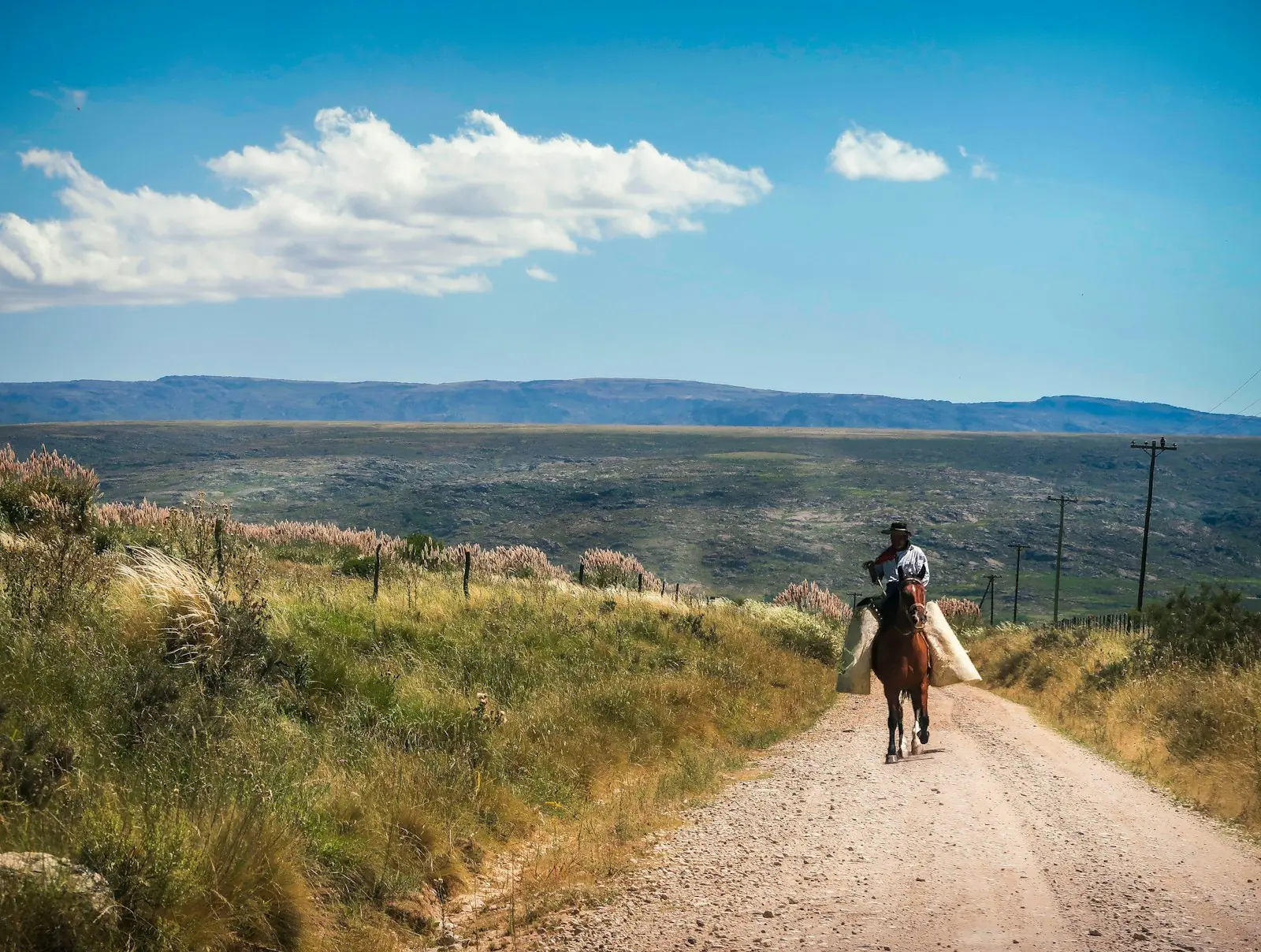 Camino de tierra en las sierras, con un jinete